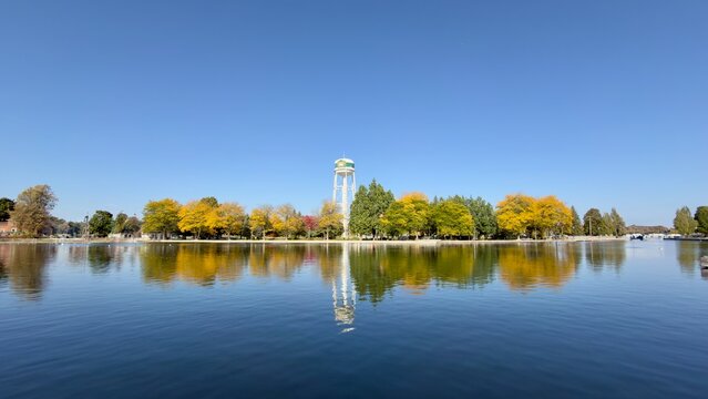 A water tower with colourful trees set against a river