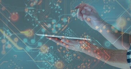 Hands in checkered shirt holding tablet with stylus in tech studio, with graphical circuit overlay