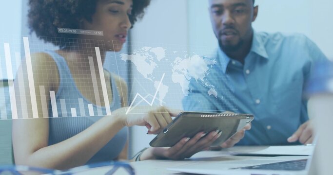 Collaborating professionals analyzing chart on tablet in conference room, with laptop and coffee