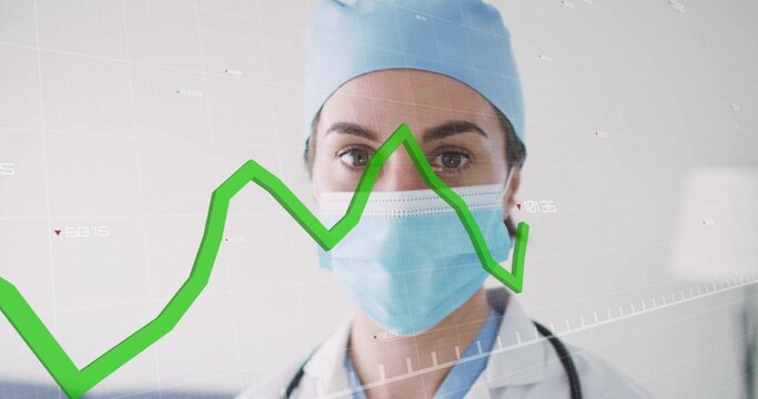Doctor wearing cap and mask analyzing data in clinic, with stethoscope, green line graph overlay