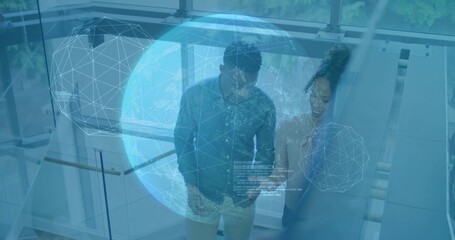 Descending two professionals conversing in modern atrium, with holographic globe and glass railing