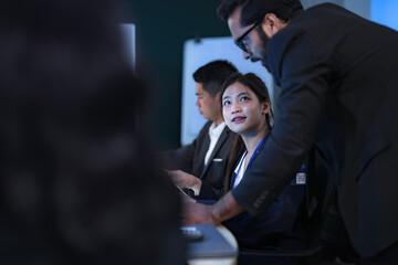 A senior IT specialist guides a new female software developer through the company's system architecture, providing hands-on support during her technical onboarding in a modern tech hub.