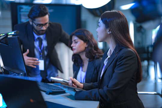 A team of financial analysts works through the night in a fast-paced firm, processing market data, reviewing performance reports, and executing trades to manage investment portfolios.