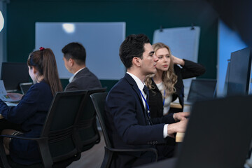 A senior manager provides one-on-one training to a smiling junior female employee in a modern...
