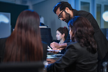 A senior manager provides one-on-one training to a smiling junior female employee in a modern...