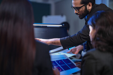 A senior manager provides one-on-one training to a smiling junior female employee in a modern...