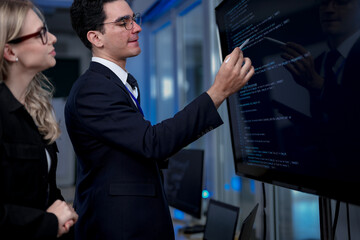 A quantum computing scientist explains a complex algorithm to a colleague, pointing to the code...