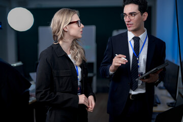 A quantum computing scientist explains a complex algorithm to a colleague, pointing to the code...