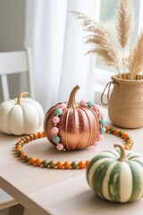Photo-realistic close-up of copper glitter wire pumpkin with blush pink and light teal beads on light wood table, surrounded by white pumpkin