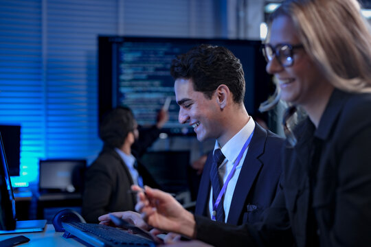 A diverse team of young professionals engages in intensive training, diligently taking notes from a presentation in a modern classroom, focused on their career growth and development.