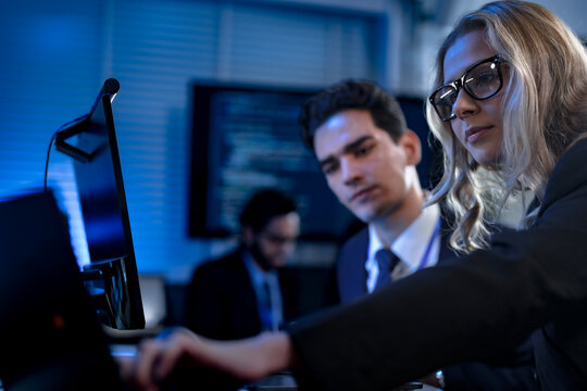 Two software developers smile with satisfaction during a pair programming session, as one points to a successfully executed block of code after solving a complex programming problem.