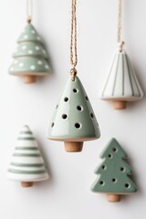 Handcrafted ceramic Christmas tree ornaments in soft greens, muted whites, light browns with varied textures, twine hangers, white background