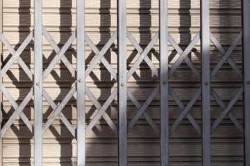Horizontal sliding steel door used for opening and closing a house, featuring abstract shadows in natural light,