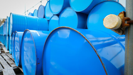 Blue chemical barrel tanks and containers stored in a warehouse represent organized industrial...
