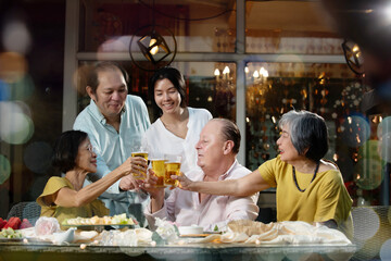 Senior friends dinner party celebration with family support, retirement joy, learning new technology together, outdoor evening activities and warm smiles create connection and comfort