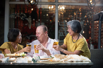 Senior friends toasting beer garden celebration outdoor evening light cheerful mood retirement learning technology activities friends