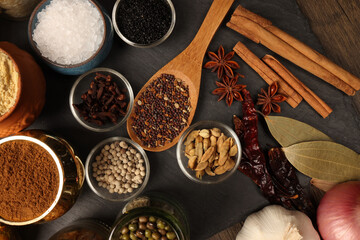 Overhead top view flat lay colourful array of spices herbs powder blue clay ceramic brass metal pot...