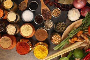 Overhead flat lay vibrant colourful spices herbs fresh produce vegetables legumes on wooden table spread splash smoking spice mix dark black slate metal clay pot palm leaf plate board copy text frame