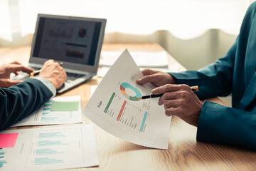 Group of business people discussing charts and graphs showing success of office meeting to analyze financial reports, planning strategies and collaboration efficiency.