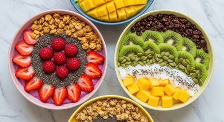 Overhead shot of four colorful smoothie bowls isolated on white background, featuring mango, kiwi, strawberries, raspberries, granola, and chia seeds for a nutritious meal