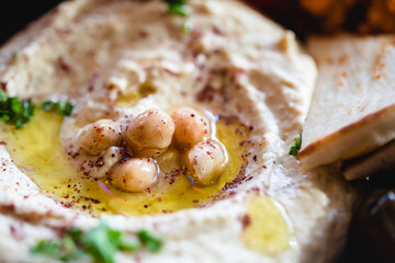 Close up detail shot of homemade hummus appetizer with chickpeas in olive oil on top as a garnish at a restaurant  © heather linn photo