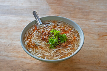 Rice noodle thick soup on wooden table 