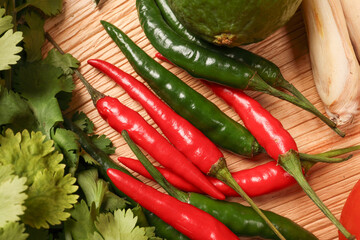 Fresh Red And Green Chile Peppers With Cilantro On A Rustic Wooden Surface