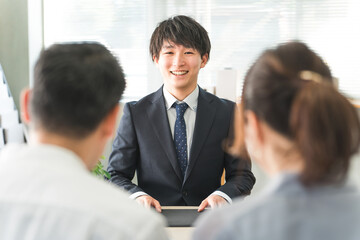 A young Asian businessman serving a couple
