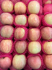 Fuji apples are seen neatly arranged with protective foam packaging in traditional or modern markets, fresh and high-quality imported or exported organic fruit.