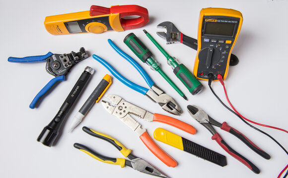 Herramientas profesionales de electricista para realizar trabajos comerciales industriales y residenciales de electricidad sobre un fondo o mesa blanca