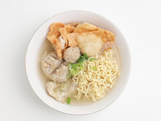Meatball soup with noodles and fried dumpling in white bowl