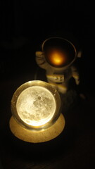 small statue or figure of a white astronaut on a dark background