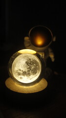 small statue or figure of a white astronaut on a dark background