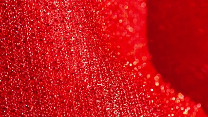 Red glitter macro background with shining bokeh .iridescent gradient texture.Folds of shiny fabric in red tones. 4k footage - Powered by Adobe