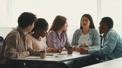 A group of diverse students engages in collaborative study at a university. They share ideas, taking notes and discussing while seated at a table with coffee cups. - Powered by Adobe
