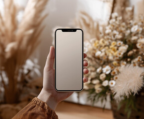 Hand holding a blank-screen mobile phone