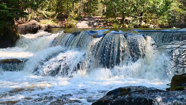 Upper Bond Falls cascading over rock ledges in Michigan&rsquo;s Upper Peninsula, surrounded by forest and sunlight, filmed in 4K 60fps UHD with natural waterfall sound