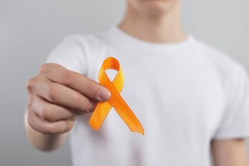 Orange Ribbon Awareness Held by Person