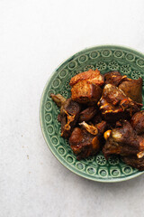 overhead view of fried goat meat on a green plate, top view of fried mutton