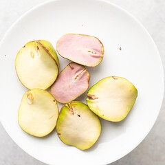 Overhead view of open kola nut on white granite countertop, top view of fresh split kolanut on a white plate