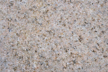 ピンクがかった石のざらざらした表面のクローズアップ。凹凸少なめ。石や岩のテクスチャー