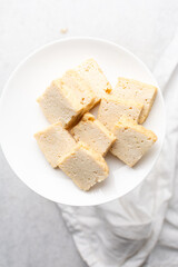 Overhead view of sliced firm tofu, top view of slices of soya bean tofu on a white plate