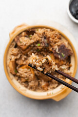 Overhead view of vegan claypot rice with pan fried tofu in chopsticks, top view of crispy rice in chopsticks