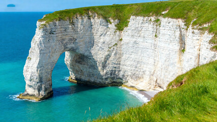 White cliff with natural arch by sea