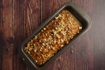 Homemade banana bread loaf with nuts on a wooden table