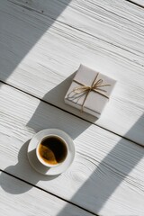 Minimalist Scandinavian Flat Lay of Coffee and Gift Box on White Wood Table, Featuring Elegant Shadow Play and Natural Lighting

