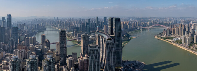Naklejka premium A detailed drone shot focusing on the impressive skybridge in Chongqing, China. An iconic piece of modern architecture overlooking the river and cityscape.