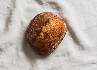 Homemade sourdough bread on a linen napkin, top view