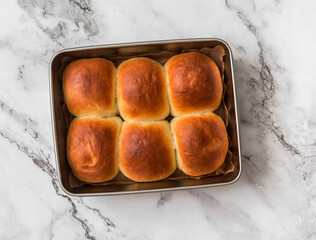Homemade buns in a baking dish on a light background, top view