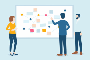 Fototapeta premium Diverse team collaborating on a project strategy using a whiteboard with sticky notes and a flowchart